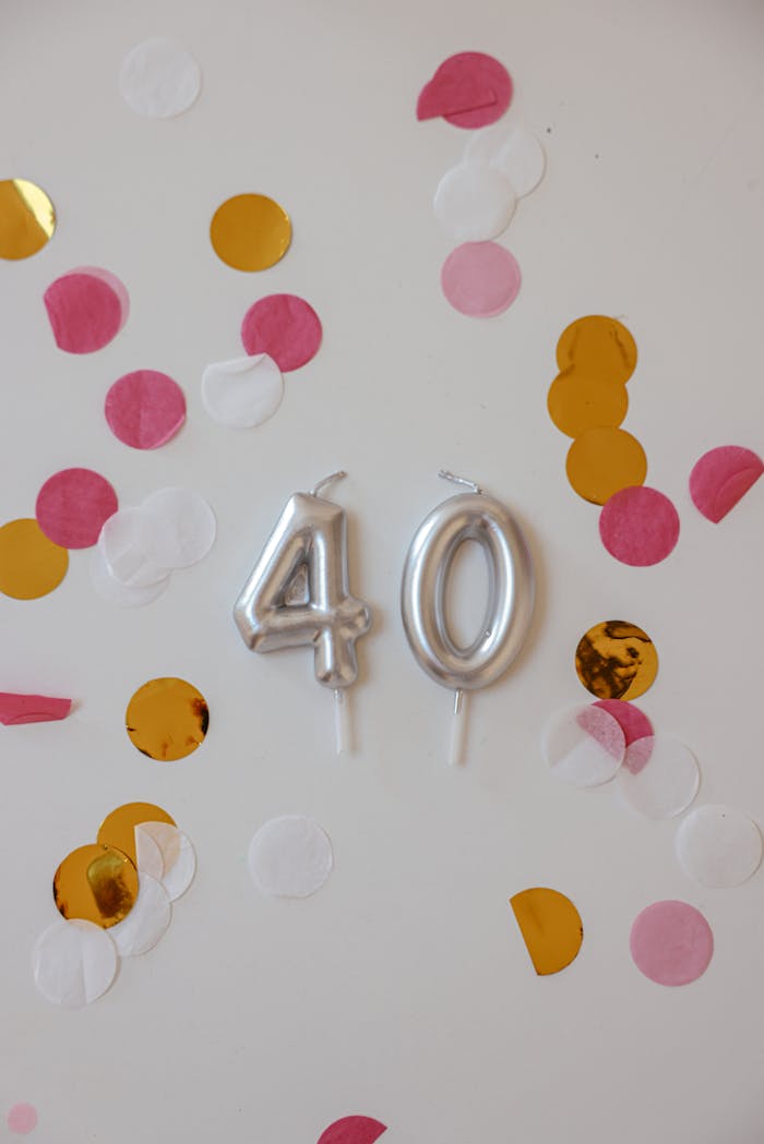 Silver 40 candles surrounded by vibrant confetti creating a festive birthday setting.